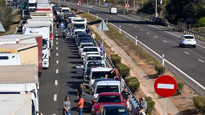 Varios conductores aguardan junto a sus vehículos en la retención causada por la colisión múltiple en la autopista AP-7, a la altura de Nules, el 15 de marzo.