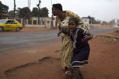 Una madre intenta poner a su hija a salvo, tras oír unos disparos cerca del distrito Miskine en Bangui (República Centroafricana), 28 de enero 2014.