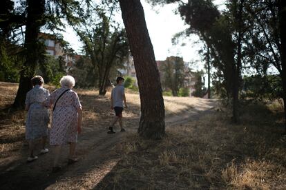 Las hermanas López caminan agarradas del brazo por el parque de la Virgen Blanca, seco durante el verano. 