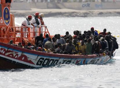 El cayuco con 179 inmigrantes a bordo a su llegada al puerto de los cristianos, en Tenerife.