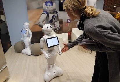 Una mujer saluda al robot Pepper durante una feria tecnol&oacute;gica en Par&iacute;s. 