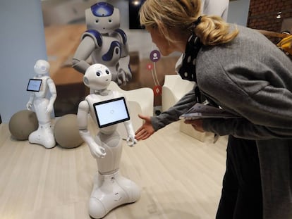 Una mujer saluda al robot Pepper durante una feria tecnol&oacute;gica en Par&iacute;s. 