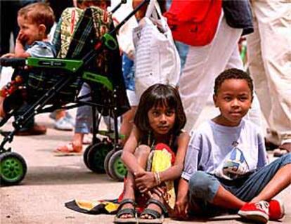 Dos niños siguen uno de los actos programados en la Fiesta de la Diversidad, ayer, en las fuentes de Montjuïc.