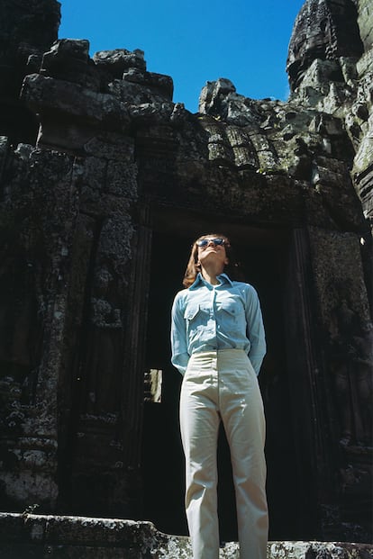No, no es un editorial de moda. Es Jackie con camisa vaquera masculina y pantalón en Angkor (Camboya). Un ejemplo a seguir por todos los turistas fanáticos de las chanclas y bermudas.