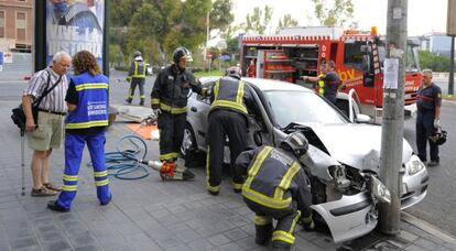 Los bomberos, durante la excarcelaci&oacute;n de una ocupante de uno de los coches. 