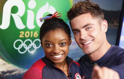 El actor estadounidense Zac Efron voló a Río de Janeiro para sorprender a Simone Biles. La atleta, que ha crecido con la película juvenil que lo convirtió en un ídolo de masas, 'High School Musical', se declaró fan suyo en una visita a un programa de televisión estadounidense. Antes de ser conocida, Biles había escrito decenas de mensajes en su cuenta de Twitter en los que mostraba lo mucho que le gustaba Efron. Tres años más tarde, y cinco medallas olímpicas después, la joven pudo conocer a la estrella en el estadio de la ciudad brasileña. Nerviosa y aún en estado de choque, la deportista y el resto de sus compañeras de equipo inmortalizaron el momento con instantáneas y vídeos que colgaron en las redes sociales. El esperado primer beso (en la mejilla) entre los dos 'celebrities' ya se ha hecho viral. ¿Quién sabe si este será el inicio de una larga amistad entre ambos?