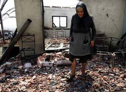 Una mujer pasea entre las ruinas de su casa en el pueblo de Artemisa, uno de los más dañados por el incendio.