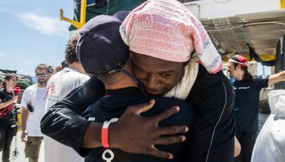 Abrazo entre uno de los migrantes y un voluntario del 'Aquarius', este domingo, en el puerto de Valencia.