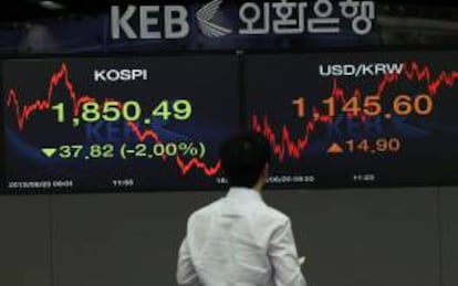 Un corredor de bolsa observa los monitores en la sede del Korea Exchange Bank en Seúl (Corea del Sur).