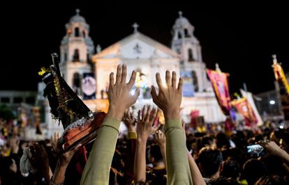 Los devotos católicos luchan por tocar la estatua de tamaño natural del Nazareno Negro cuando llega a la Iglesia de Quiapo, durante la procesión anual en Manila (Filipinas).