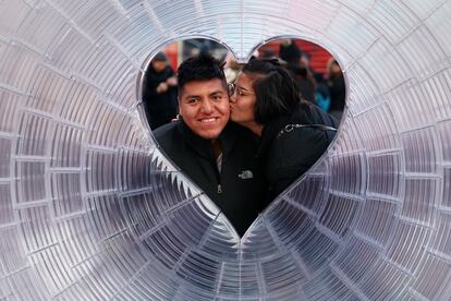 Una pareja se besa mientras posan para una foto en Times Square, Nueva York, el 2 de febrero de 2018.