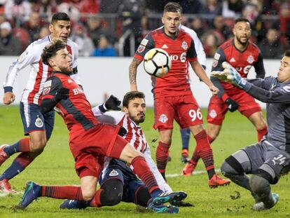 El portero Jiménez de Chivas bloquea un tiro de Osorio de Toronto.