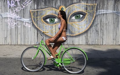 Una chica montando en bicicleta en el Ocean Front Walk de Venice Beach, en Los Ángeles (EE UU).