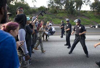 Un grupo de policías impide el paso de manifestantes en una protesta ayer en una carretera de Los Ángeles.