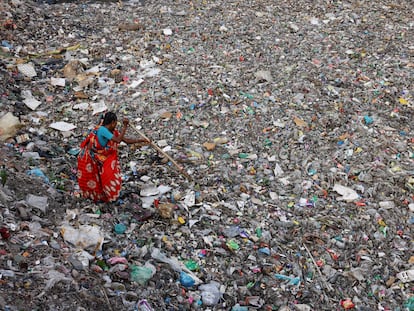 Una mujer busca botellas de plástico en Dhaka, Bangladesh