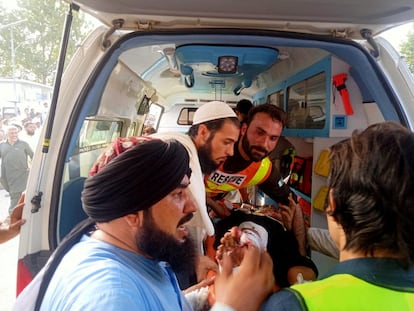 Trabajadores de los servicios de emergencias y voluntarios transportan a uno de los heridos en el atentado en Jar, en Pakistán, el 30 de julio de 2023.