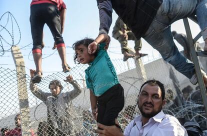 Esta imagem, publicada em junho no EL PAÍS e em outros veículos internacionais, corresponde a um dos momentos mais tensos da crise dos refugiados sírios. Os emigrantes entram na Turquia após romper a cerca que a separa da Síria. A foto do turco Bulent Kilic ganhou o terceiro lugar na categoria Atualidades – Série.