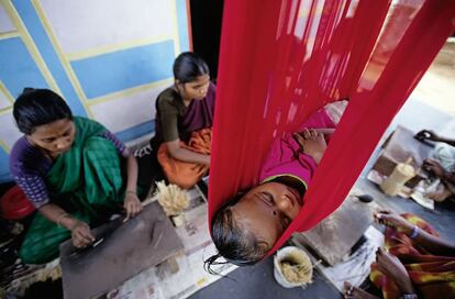 Un niño duerme mientras su mamá y otras mujeres de la comunidad fabrican incienso. El taller de incienso o agarabathi, como se denomina la variedad típica de India, fue la primera iniciativa del Centro de Formación de Gandlapenta.