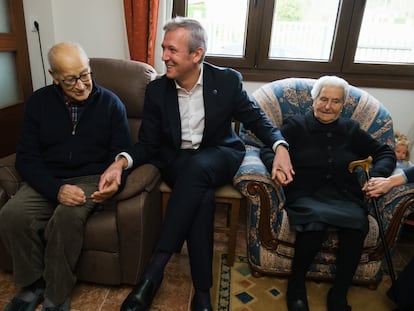 El presidente gallego, Alfonso Rueda, visita el pasado 5 de diciembre en su casa de Rois (A Coruña) a dos beneficiarios del nuevo bono para dependientes, en una imagen divulgada por la Xunta.