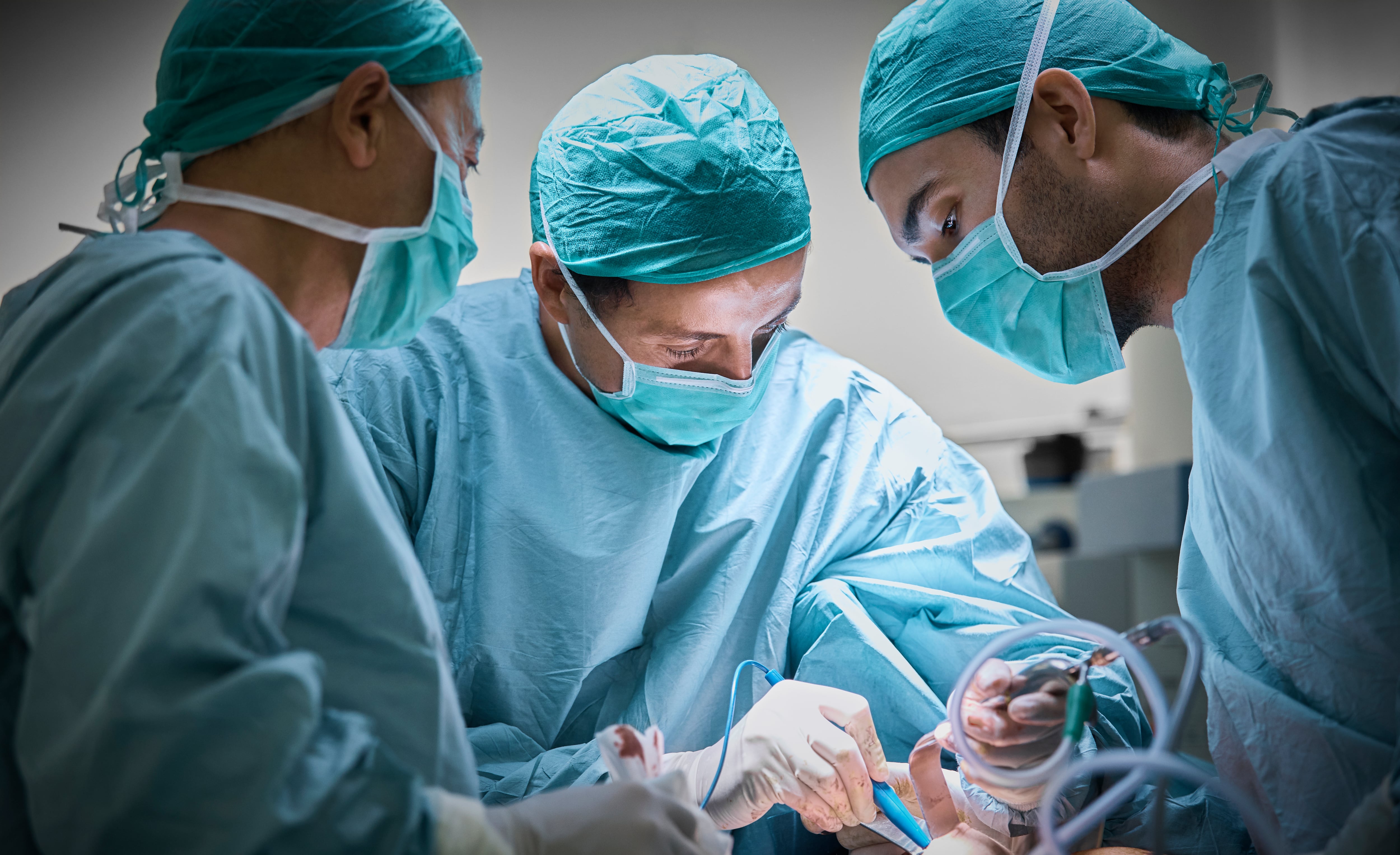 Cirujanos plásticos operando a una paciente para implantes.