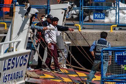 Agentes de policía turcos escoltan a uno de los migrantes deportados en el puerto turco de Dikili, el 4 de abril de 2016.