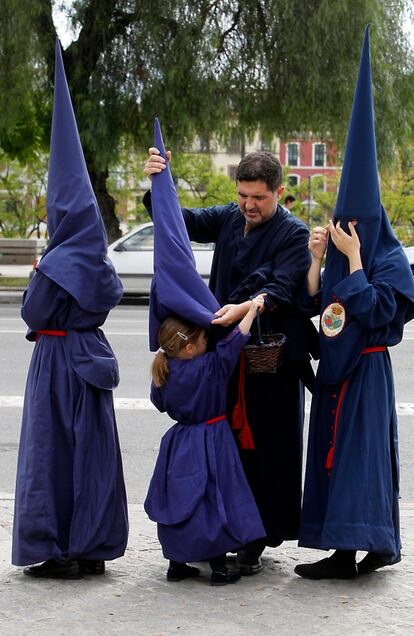 Una familia se prepara para salir el Miércoles Santo.