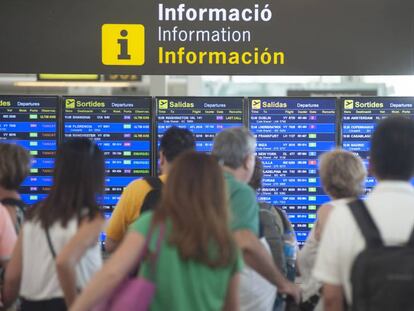 Un grupo de pasajeros mira los paneles de información en El Prat.