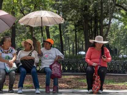 Personas se protegen de las altas temperaturas en la Alameda Central, en Ciudad de México, en junio de 2023.