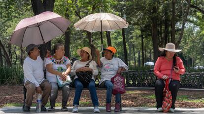 Personas se protegen de las altas temperaturas en la Alameda Central, en Ciudad de México, en junio de 2023.