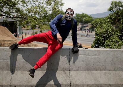 Un partidario de la oposición salta una barrera durante las protestas contra Nicolás Maduro, al que la oposición acusa de usurpar el poder.