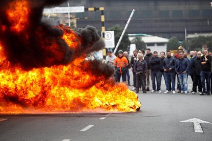 Trabajadores de la planta Alcoa de La Coruña, durante una concentración a las puertas de la fábrica, donde han quemado neumáticos y cortado el tráfico, en protesta y en lucha contra el cierre de la aluminera, que supondría el despido colectivo.