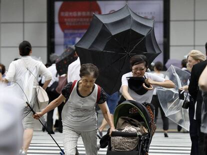 Peatones con sombrillas luchan contra los fuertes vientos y la lluvia en Tokio (Japón), el 4 de septiembre de 2018.