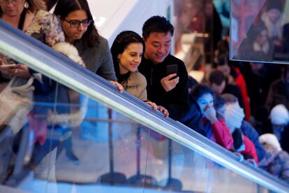 Varios clientes suben por una de las escaleras mecánicas de la tienda Macy's de Nueva York (EE UU).