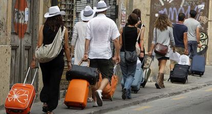 Unos turistas arrastran sus maletas, camino del hotel, en el centro de Valencia