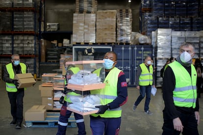 Preparativos de urnas para el 14-F, con equipos de protección para los miembros de las mesas, en los almacenes del Ayuntamiento de Barcelona.