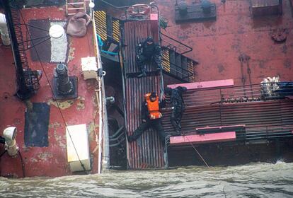 Trabajadores evacúan a un miembro de la tripulación del buque cisterna 'Delfi' de Moldavia, tras una fuerte tormenta cerca del puerto de Odesa (Ucrania), en el mar Negro, el 22 de noviembre.