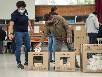 Dos personas votan en un centro electoral en Bogotá Colombia, el 13 de marzo de 2022.