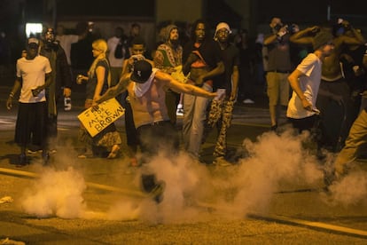 Un manifestante pega una patada a un bote de gas lacrimógeno en dirección hacia el lugar desde donde lo había lanzado la policía previamente.