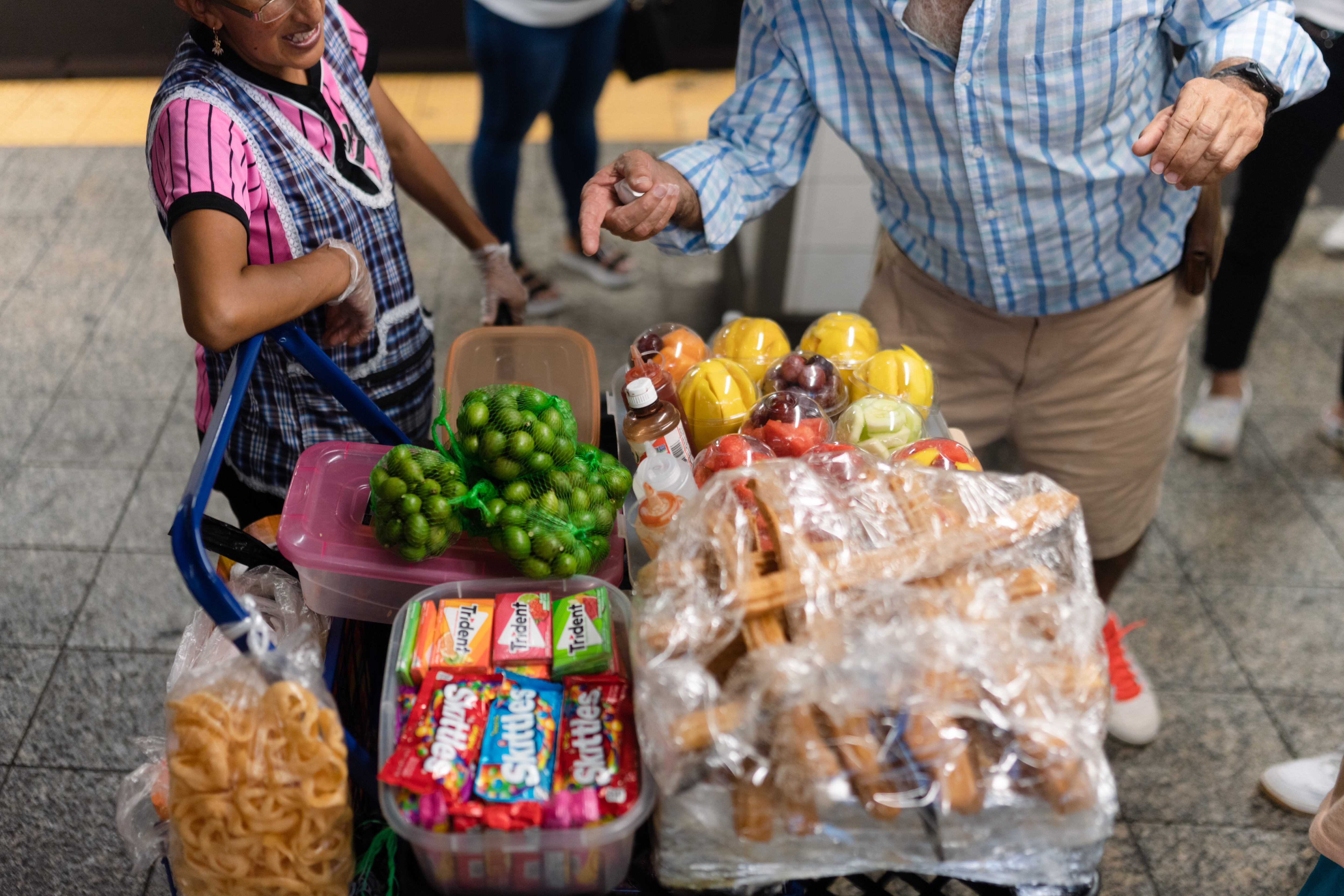 Una mujer vende fruta a un turista en un andén del metro de la ciudad de Nueva York, en junio pasado.