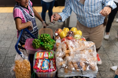 Una mujer vende fruta a un turista en el andén del metro de la estación Grand Central el miércoles 26 de junio de 2024 en la ciudad de Nueva York.