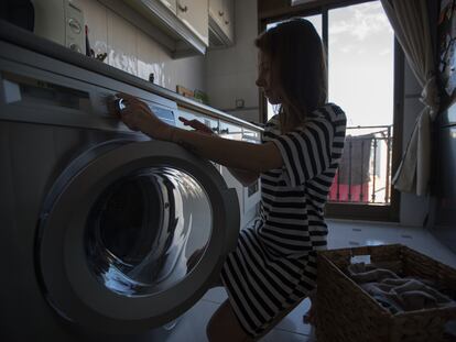 Mujer pone una lavadora en su domicilio.