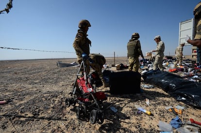 Soldados egipcios recogen pertenencias de las víctimas del accidente de avión que se estrelló en la península del Sinaí de Egipto.