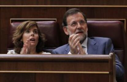 La portavoz del PP en el Congreso, Soraya Sáenz de Santamaría, aplaude junto al líder de su formación, Mariano Rajoy