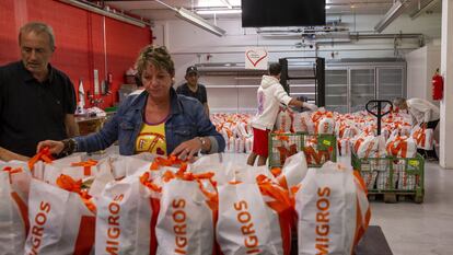 Un grupo de voluntarios preparan bolsas con alimentos en Carouge, Suiza.