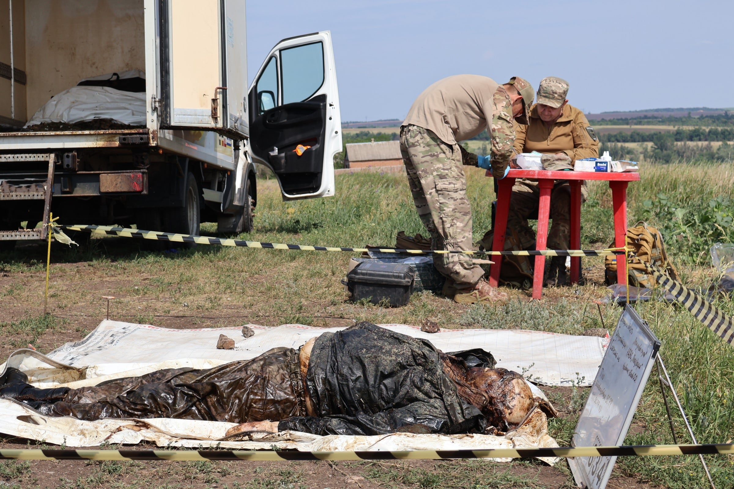 Expertos del grupo ucranio de exhumación de cadáveres Platsdarm analizan soldados rusos muertos, el 10 de junio en Donetsk.