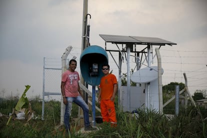 Telecom workers Marcos (R) and Caio (L), pose next to a phone booth that they built in Rio Pardo next to Bom Futuro National Forest, Porto Velho, Rondonia State, Brazil, August 31, 2015. The town of Rio Pardo, a settlement of about 4,000 people in the Amazon rainforest, rises where only jungle stood less than a quarter of a century ago. Loggers first cleared the forest followed by ranchers and farmers, then small merchants and prospectors. Brazil's government has stated a goal of eliminating illegal deforestation, but enforcing the law in remote corners like Rio Pardo is far from easy. REUTERS/Nacho DocePICTURE 33 OF 40 FOR WIDER IMAGE STORY "EARTHPRINTS: RIO PARDO" SEARCH "EARTHPRINTS PARDO" FOR ALL IMAGES