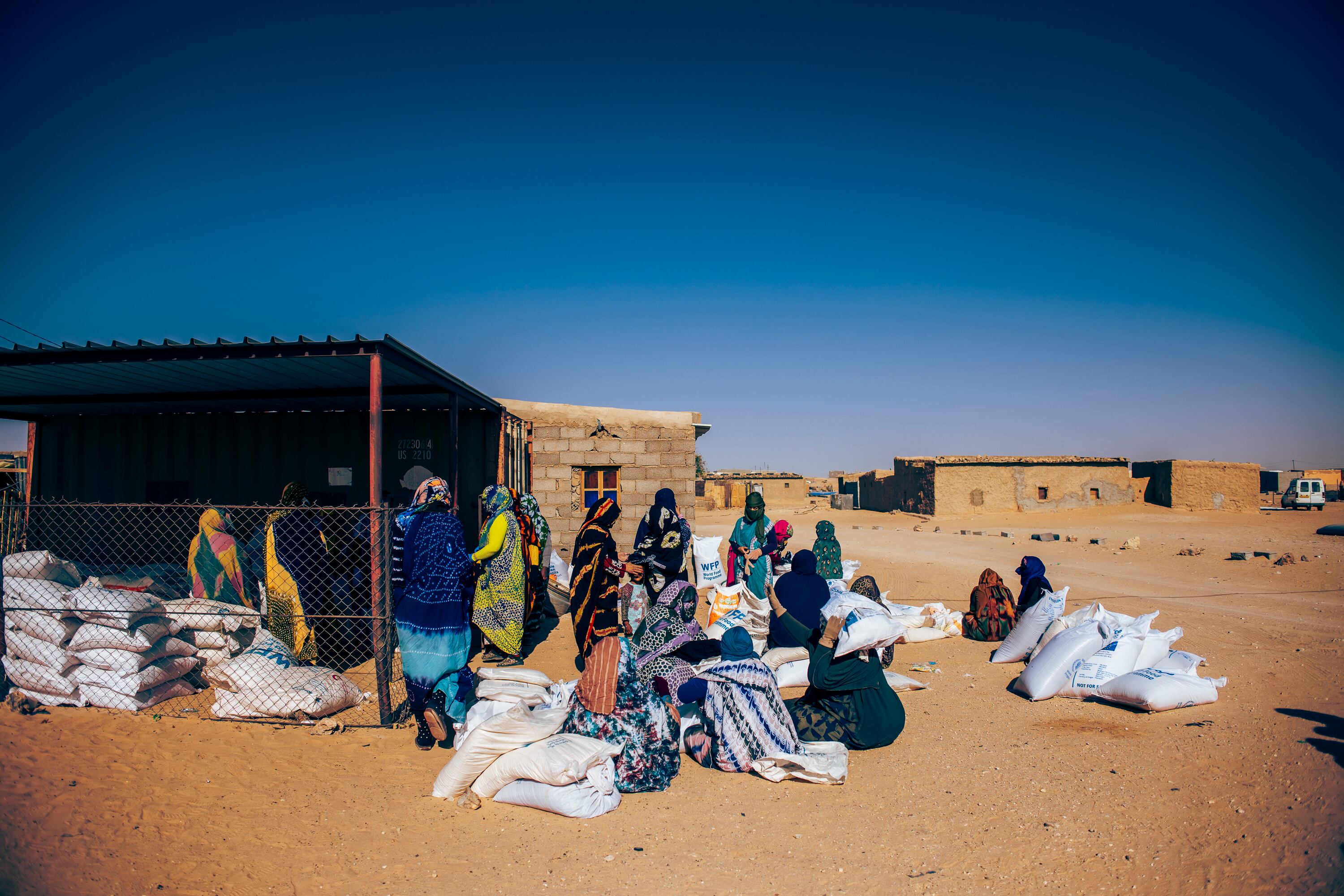 Es día de reparto en la wilaya de Auserd. Un grupo de refugiadas voluntarias apila los sacos por grupos para agilizar el reparto y evitar las peores horas de calor. A medio día, el termómetro marca más de 40ºC. 