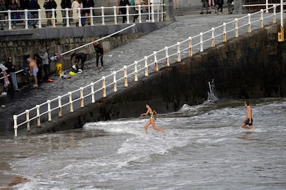 Dos personas se bañan en la playa de San Lorenzo, el miércoles en Gijón.