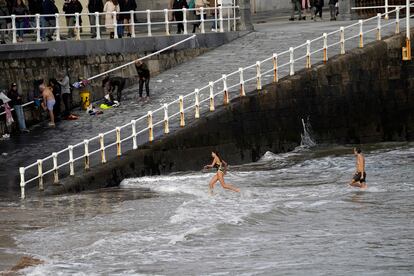 Dos personas se bañan en la playa de San Lorenzo, el miércoles en Gijón.