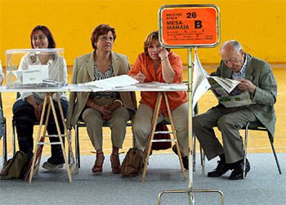 Miembros de una mesa electoral en un colegio de Vitoria aguardan a los votantes.